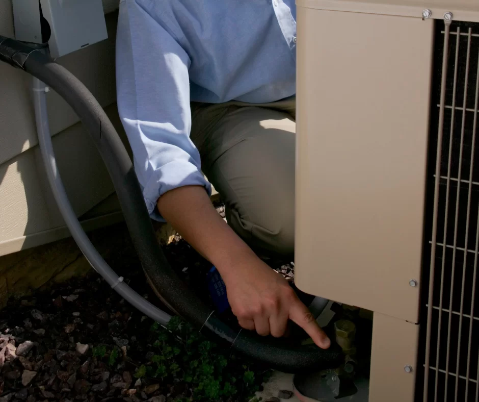 person inspecting air conditioning system