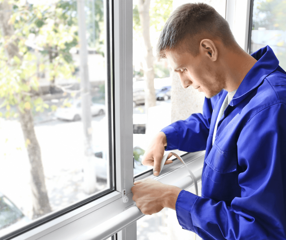 man sealing office windows to help with energy efficiency